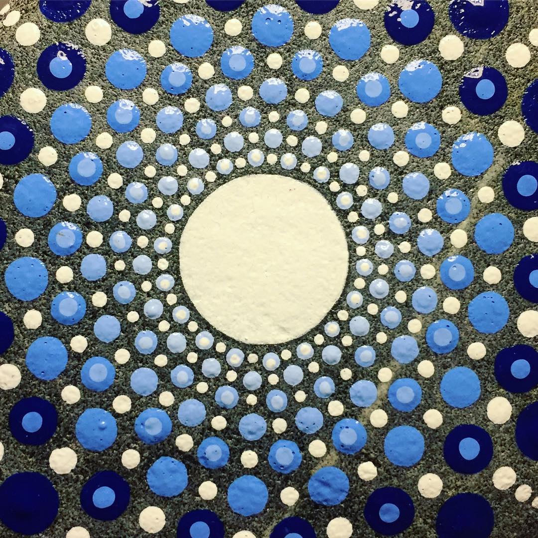 Blue dots of paint on a stone