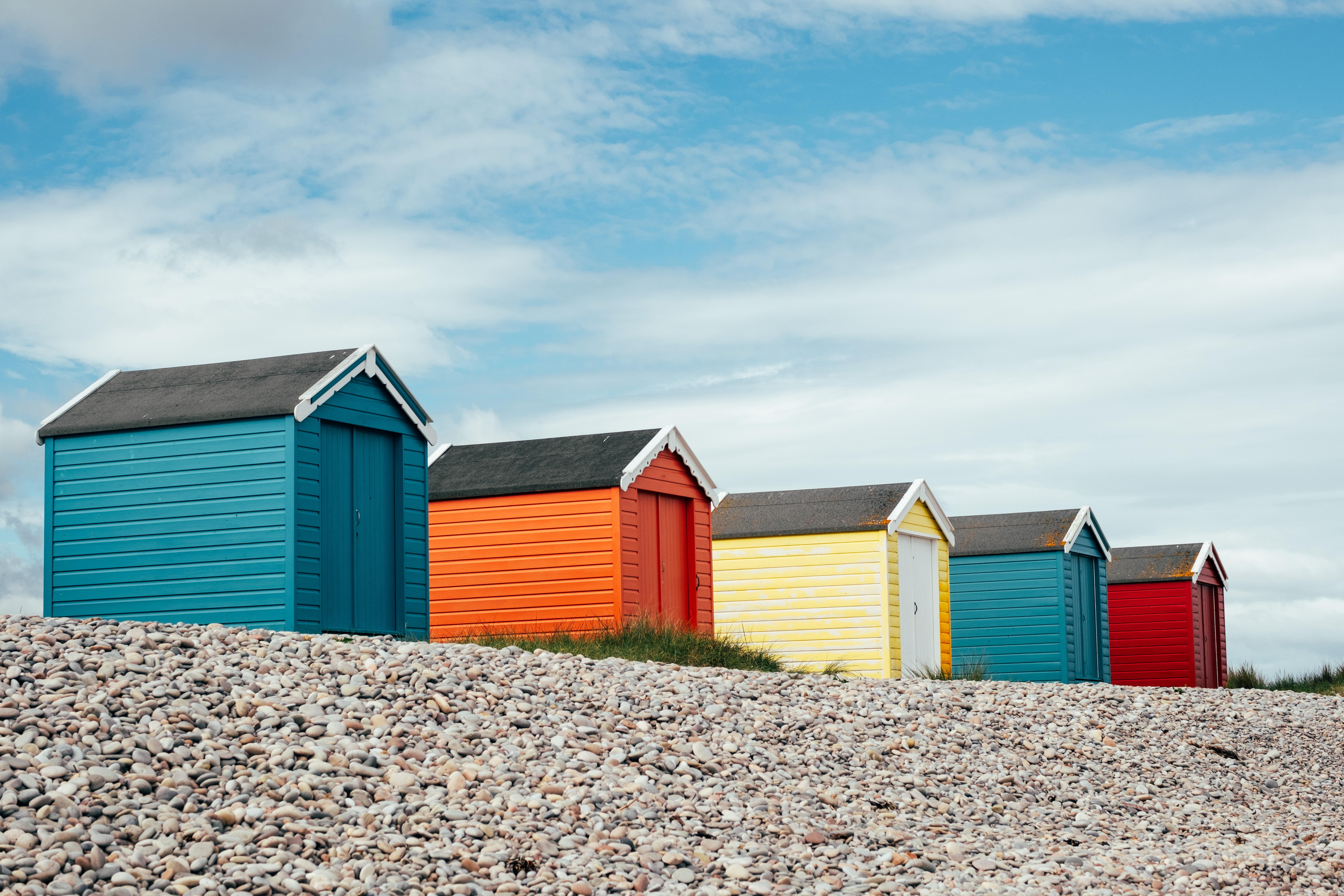 A cheerful row of seaside shelters.